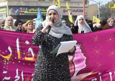 woman speaking at a rally for international womens day in Raqqa