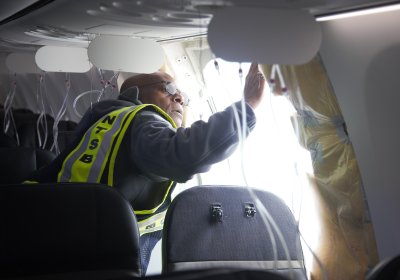 man inspects damaged aircraft