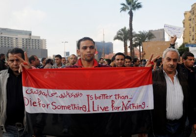 Protester with flag that has the message 'Die for something is better than.. live for nothing'.