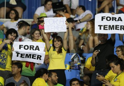 Fans hold “Fora Temer” signs