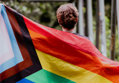 A person holding a LGBTQI rights flag.