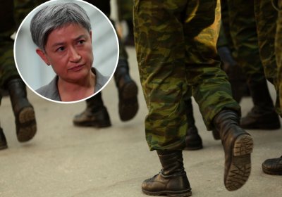 Foreign Affairs Minister Penny Wong with background of soldiers