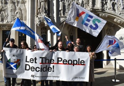 Campaigners hold sign saying "Let the people decide!"
