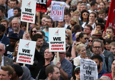 Protesters hold up a placards in support of Leader of the opposition Labour Party Jeremy Corbyn outside parliament during a pro-Corbyn demonstration in London in June last year.