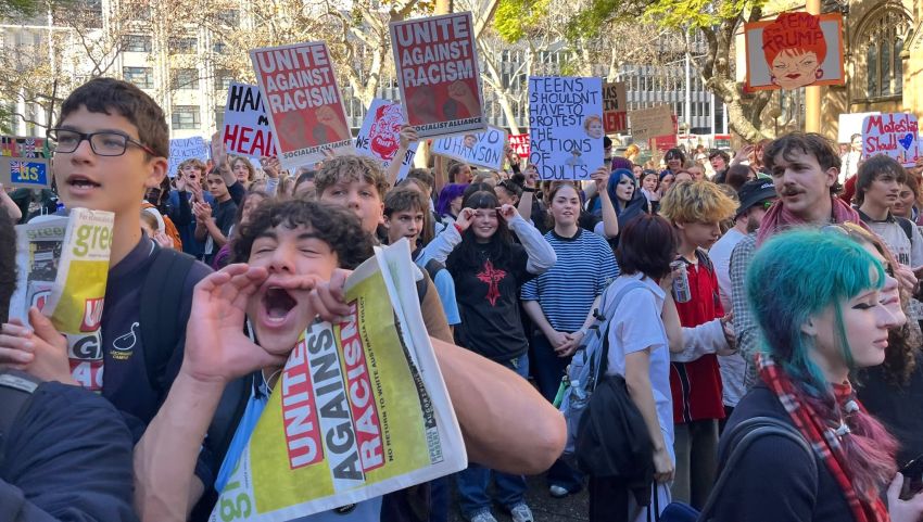 students holding green left and socialist alliance posters 