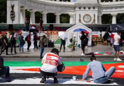 protesters in a city square with a banner