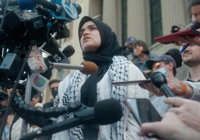 A woman in a hijab addresses the media