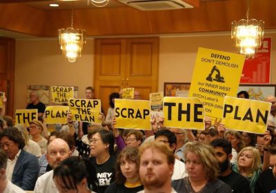 people hold scrap the plan signs