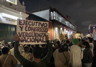 protesters in Peru with a sign reading:'Executive and Congress are a disgrace'