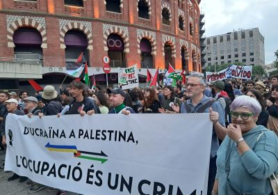 protesters marching with a banner that reads: 'From Ukraine to Palestine: Occupation is a crime"