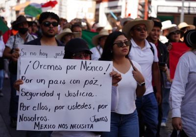 Protesters, with one carrying a sign