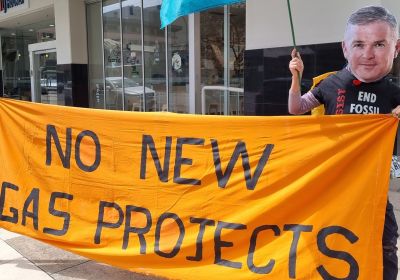 Cropped photo of Extinction Rebellion South Australia protestor holding No New Gas Projects banner and Extinction Rebelllion flag