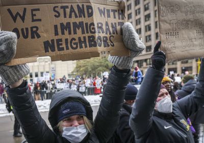 Anti-ICE protestor holding pro-migrant placards at anti-ICE protest in US