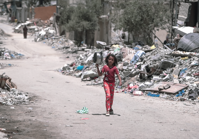 Young Palestinian girl walks along a road