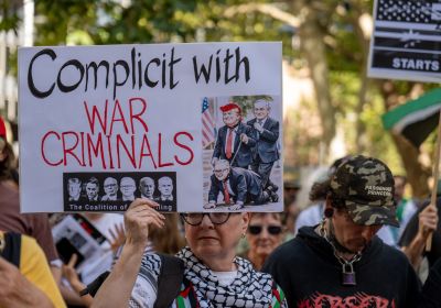 sign from a protest in Sydney against the war on Iran reading: 'complicit with war criminals'