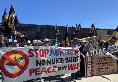 Protesters with banners and flags at an anti-AUKUS protest