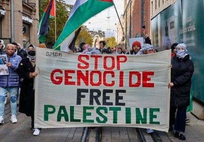 Protesters holding a banner that says Stop Genocide, Free Palestine