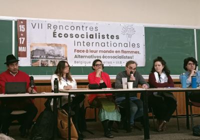 people sitting at a table with a banner on the wall behind them