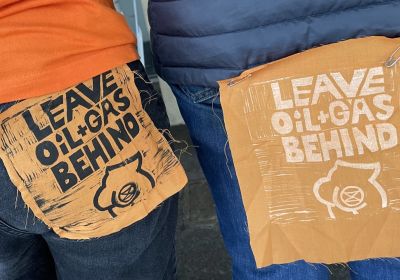 Leave Oil & Gas Behind patches on clothing of Dump Santos protesters