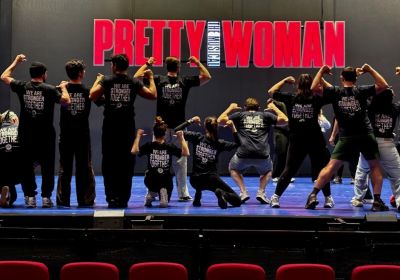 A cropped photo of MEAA members wearing MEAA t-shirts on a stage