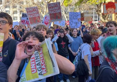 students holding green left and socialist alliance posters 
