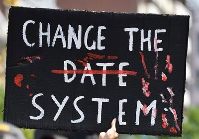 Hand painted sign that says Change the System