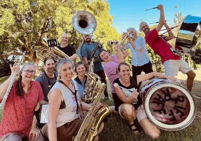 Cropped group profile photo of Riff Raff Radical Marching Band Magandjin/Brisbane crew with their instruments in a park