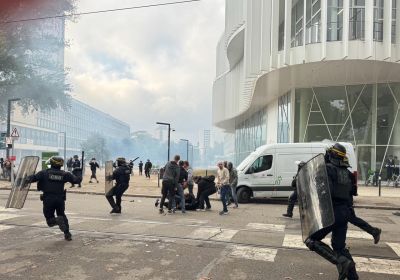 cops running with shields and batons and tear gas