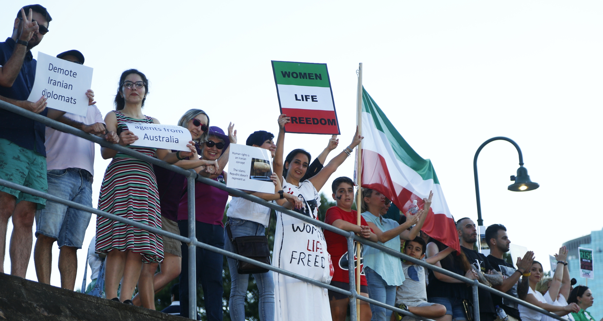 A human chain holds signs by the river at Kangaroo Point